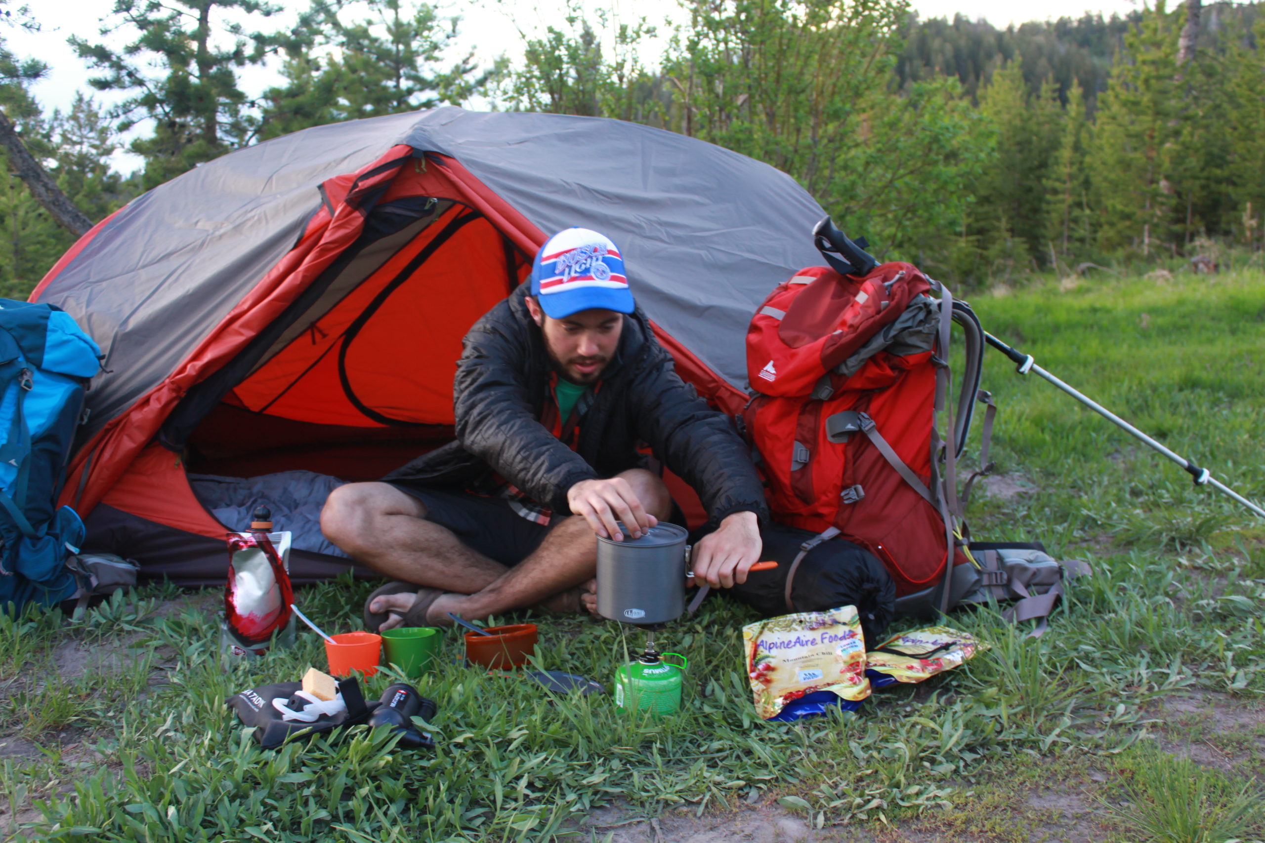 man with tent with camping gear